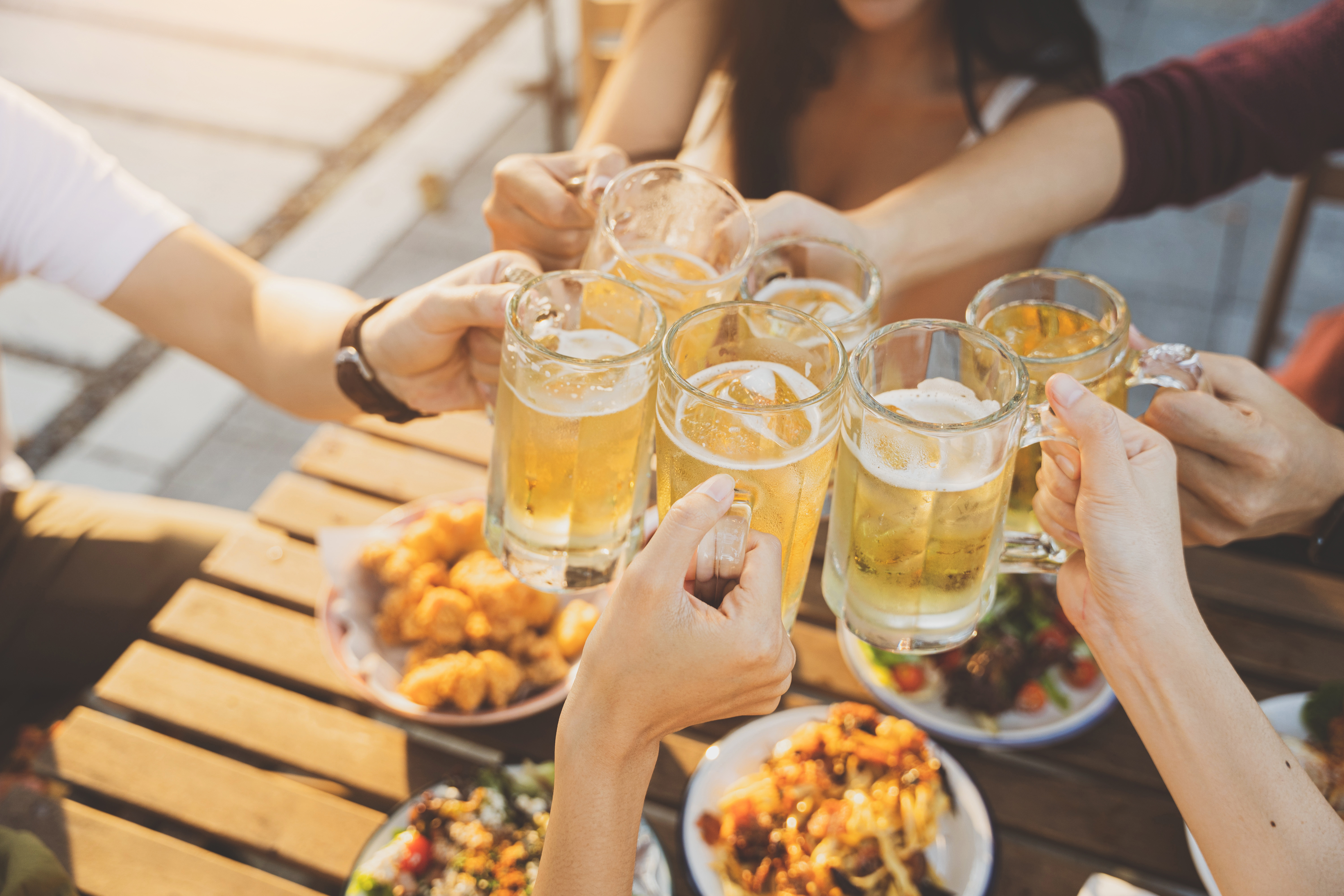 Anstoßen mit Bierkrügen im Biergarten